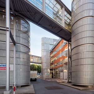 Façade industrielle de Métropole 19 avec passerelle vitrée et escalier en colimaçon, local de production Paris 19